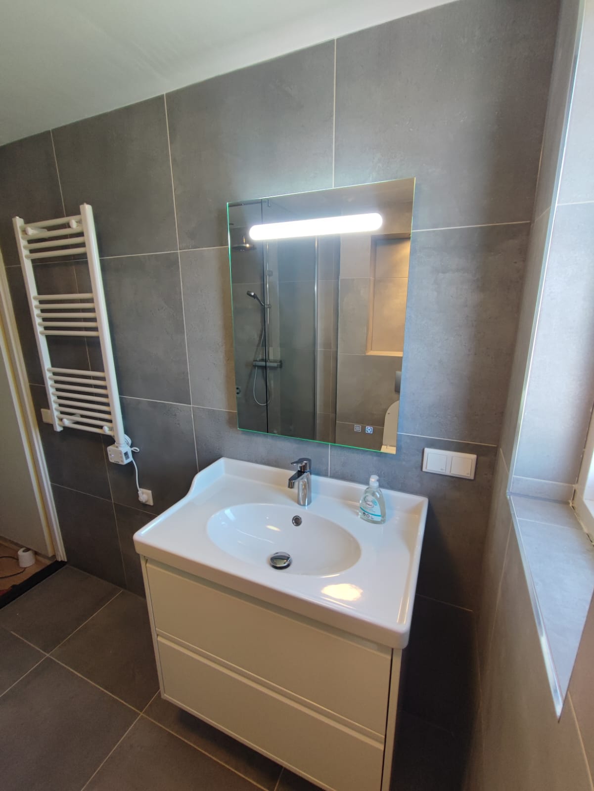 Professionele tegellegger aan het werk met precisie tegelplaatsing UNM Tegelzetbedrijf Deventer